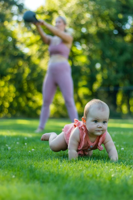 a young baby girl crawling on the grass