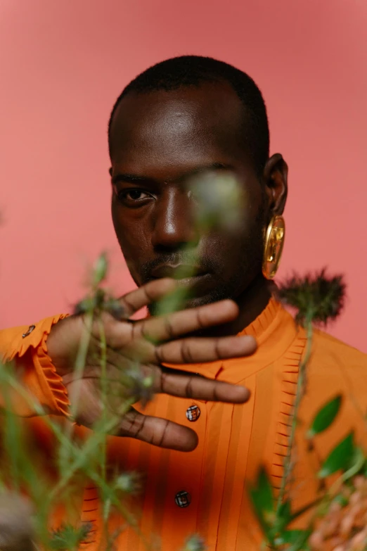 an african american man standing in front of a plant