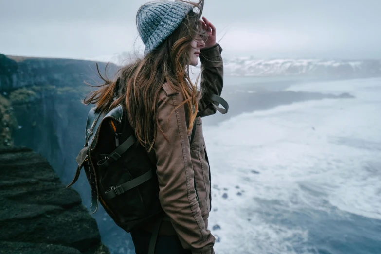 a woman with dreadlocks looking out over the ocean