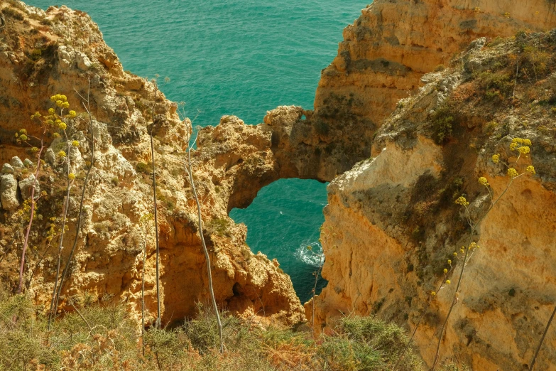 a cliff with several large rocks near water