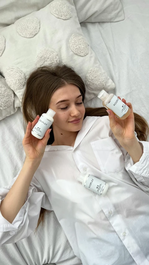 a woman is laying down and holding two different products