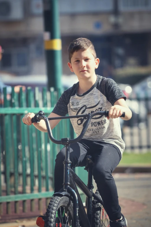 a  riding on the back of a black bicycle