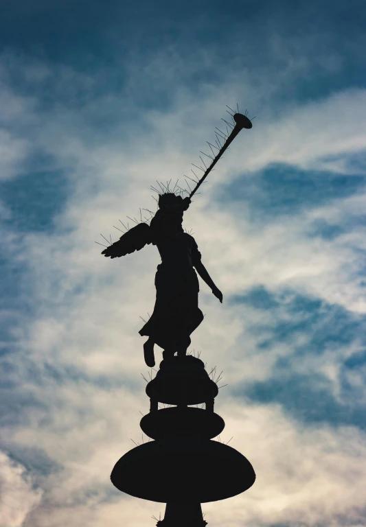 an angel statue is next to a pole with a key on it