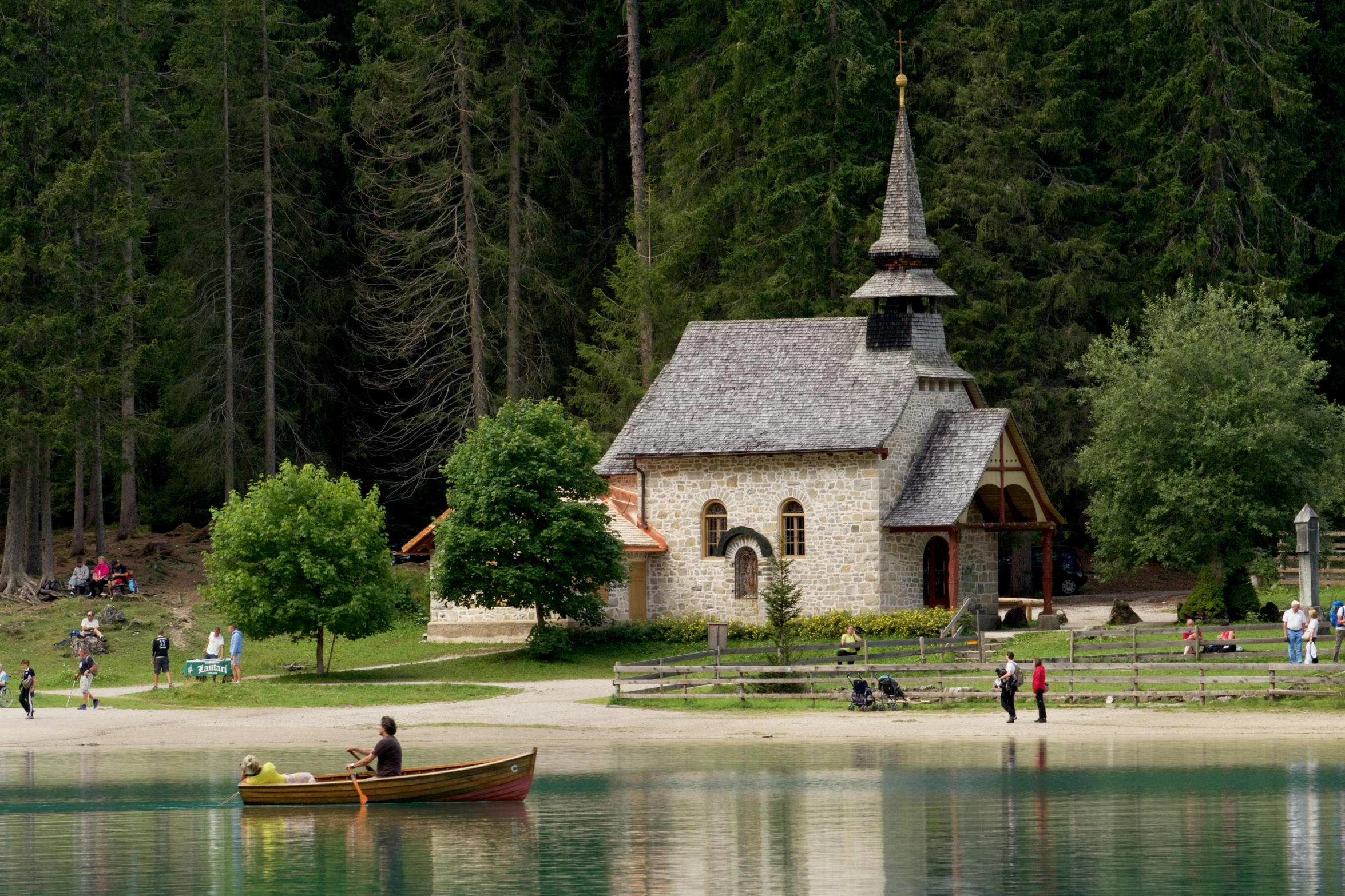 a small boat floating on top of a lake next to a building