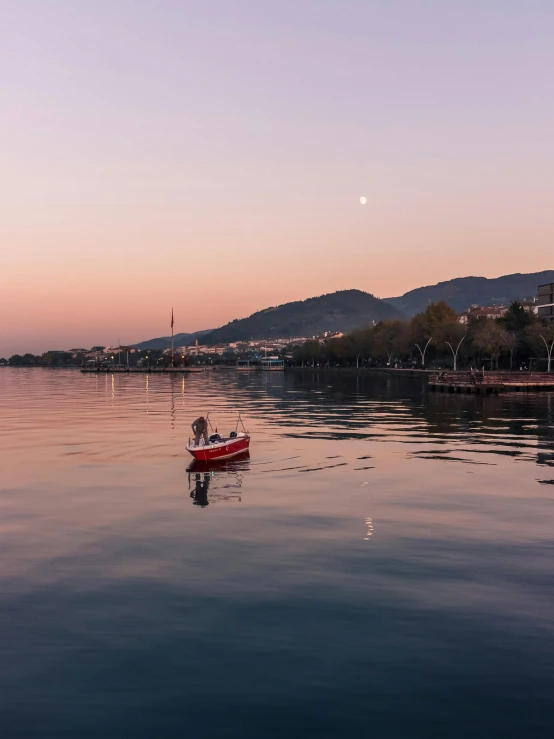 a small boat with a dog riding it across the water