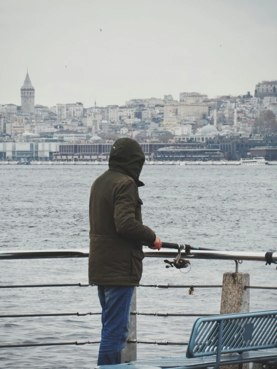 there is a man fishing by the water with his boat