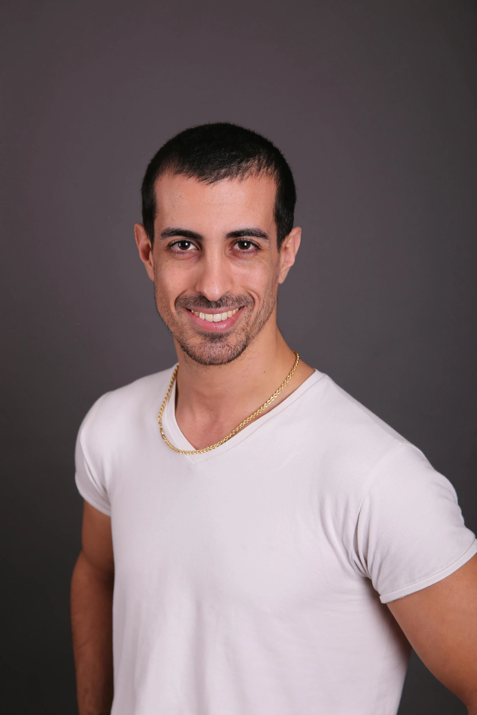 a man wearing a white shirt and a golden necklace