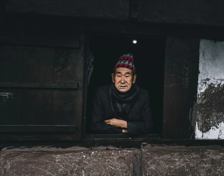 a man standing in a window with his arms crossed