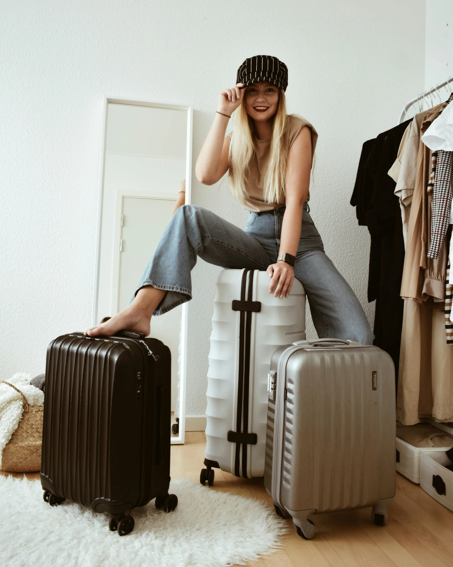 the woman poses in a room with some suitcases