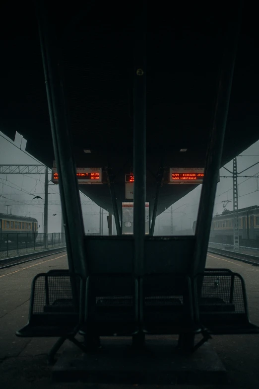 an empty train station at night with the lights on