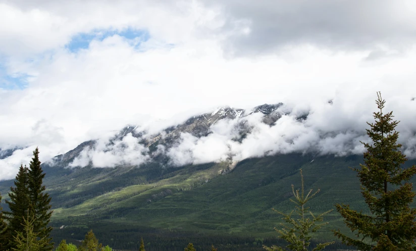 a scenic scene of the mountains with clouds on the top