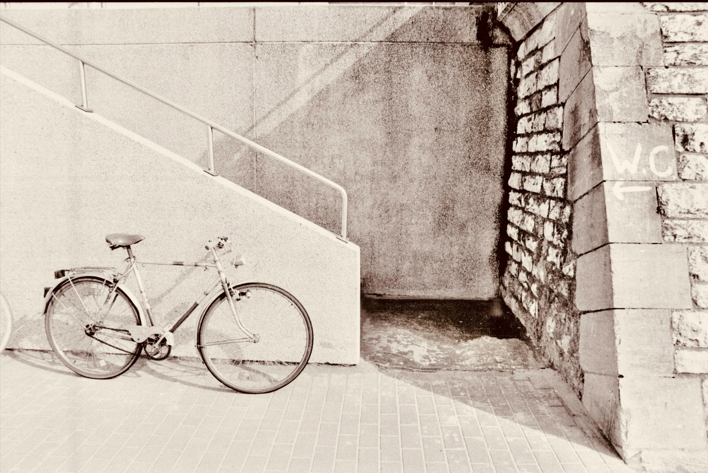 the bike is leaned up against the brick wall