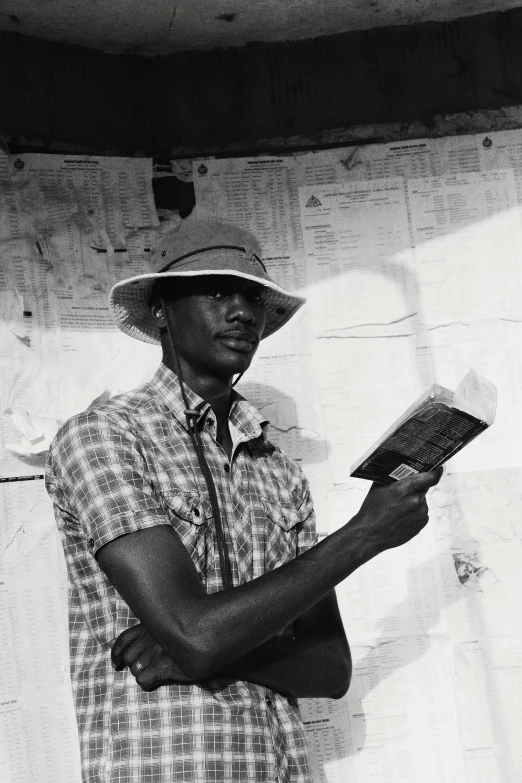 a black man is wearing a white hat holding a book