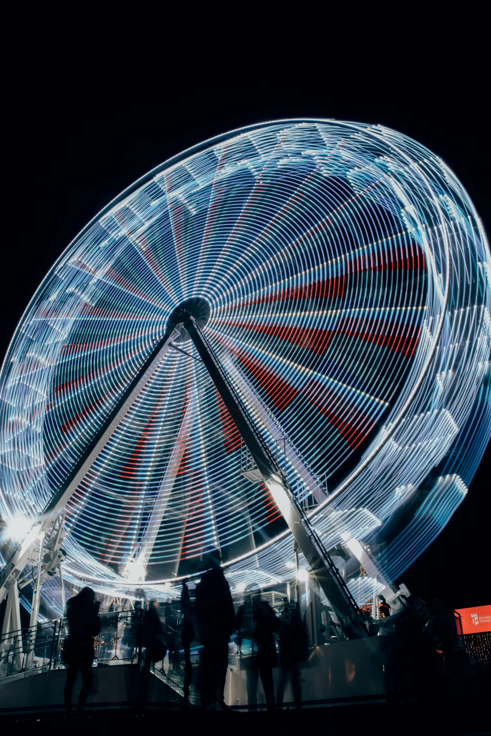 some people are standing around a large wheel