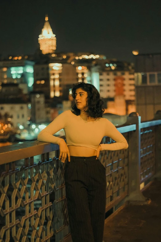 a woman standing on a bridge over a city skyline