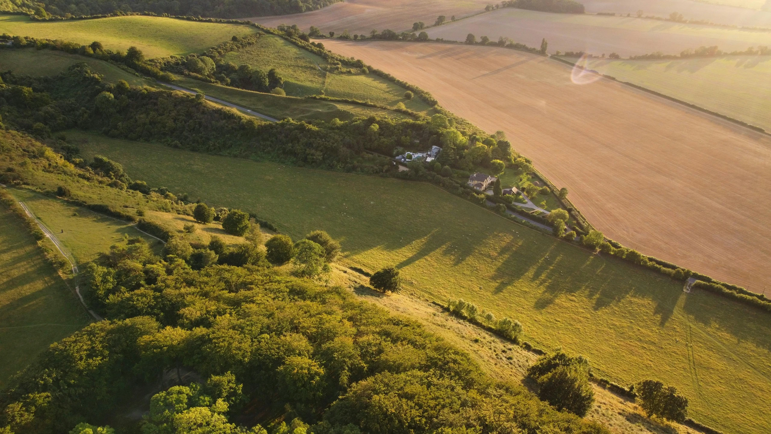 the farm land is green and has rolling grass on it