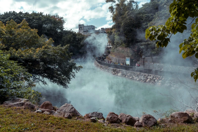 steam rises from the water, as a train passes by