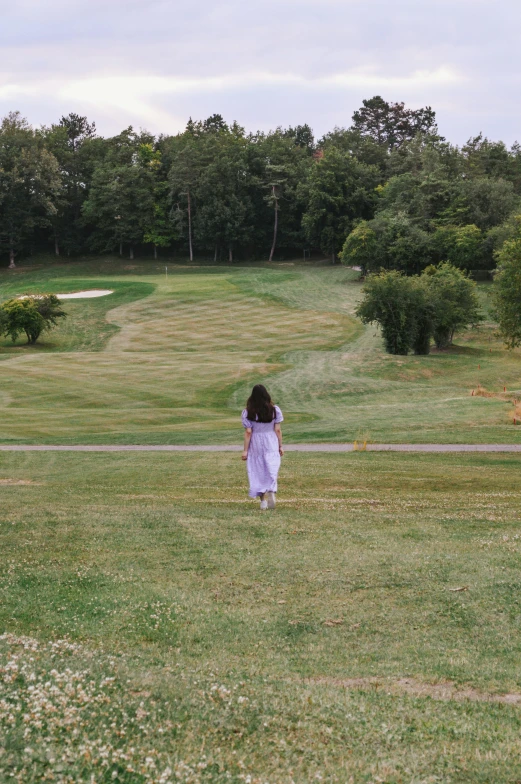 a girl is in a field with grass