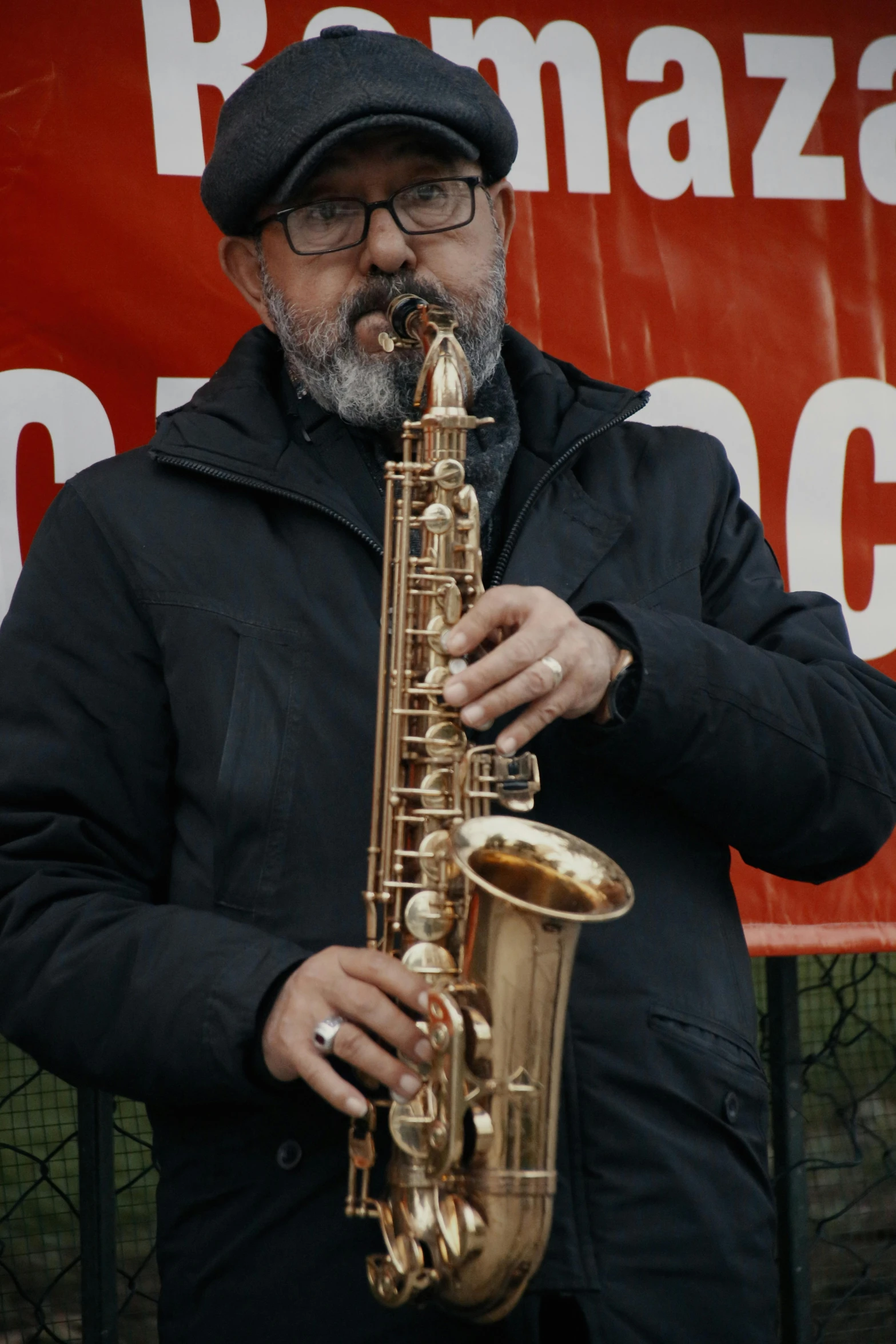 a man playing a saxophone in front of a sign