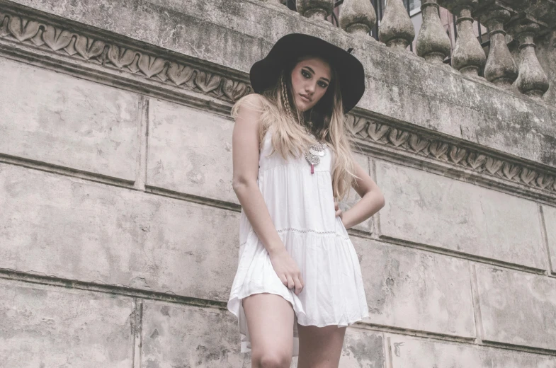 woman in dress and hat posing for picture