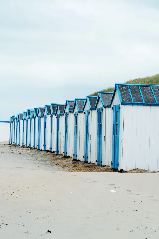 several white and blue huts with sky in background