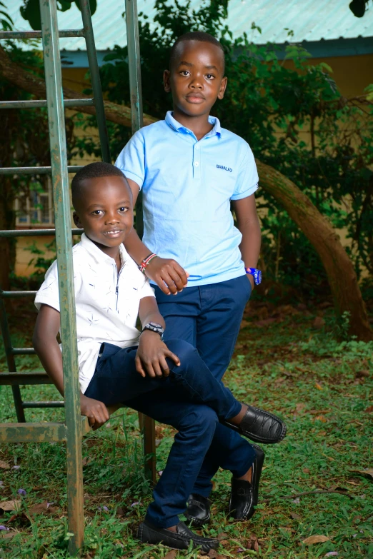 two black boys posing for the camera, wearing blue pants