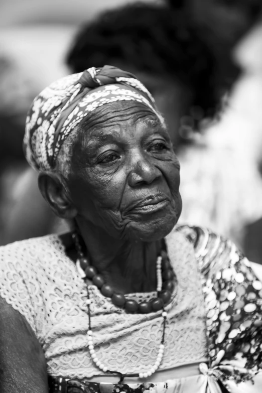 an old woman looks on while sitting with a smile