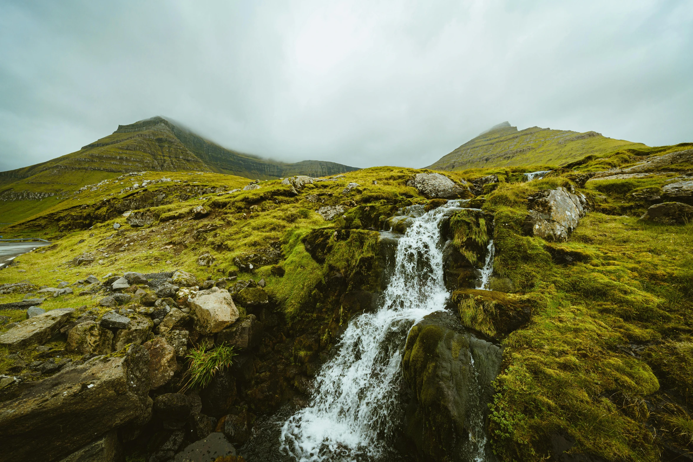 the waterfall is next to some very large rocks