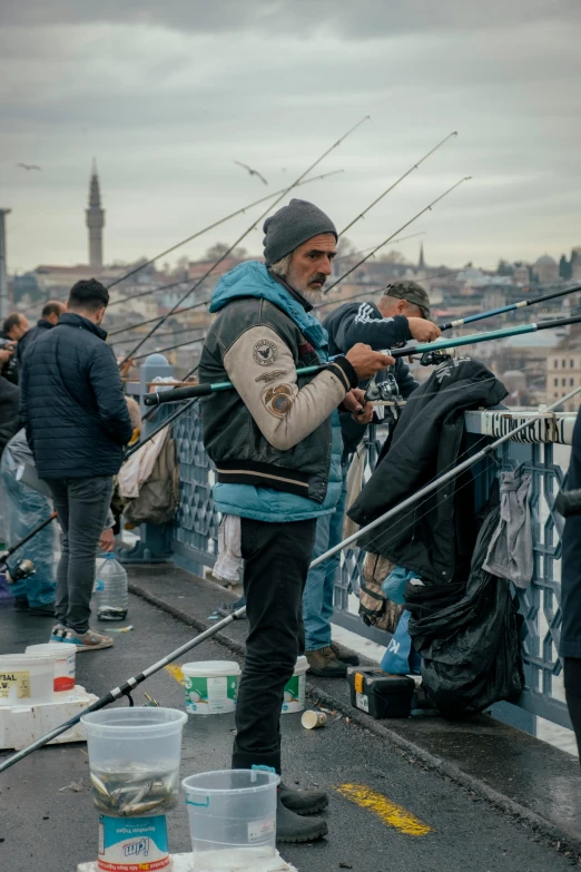 a man is holding fishing rods on a bridge