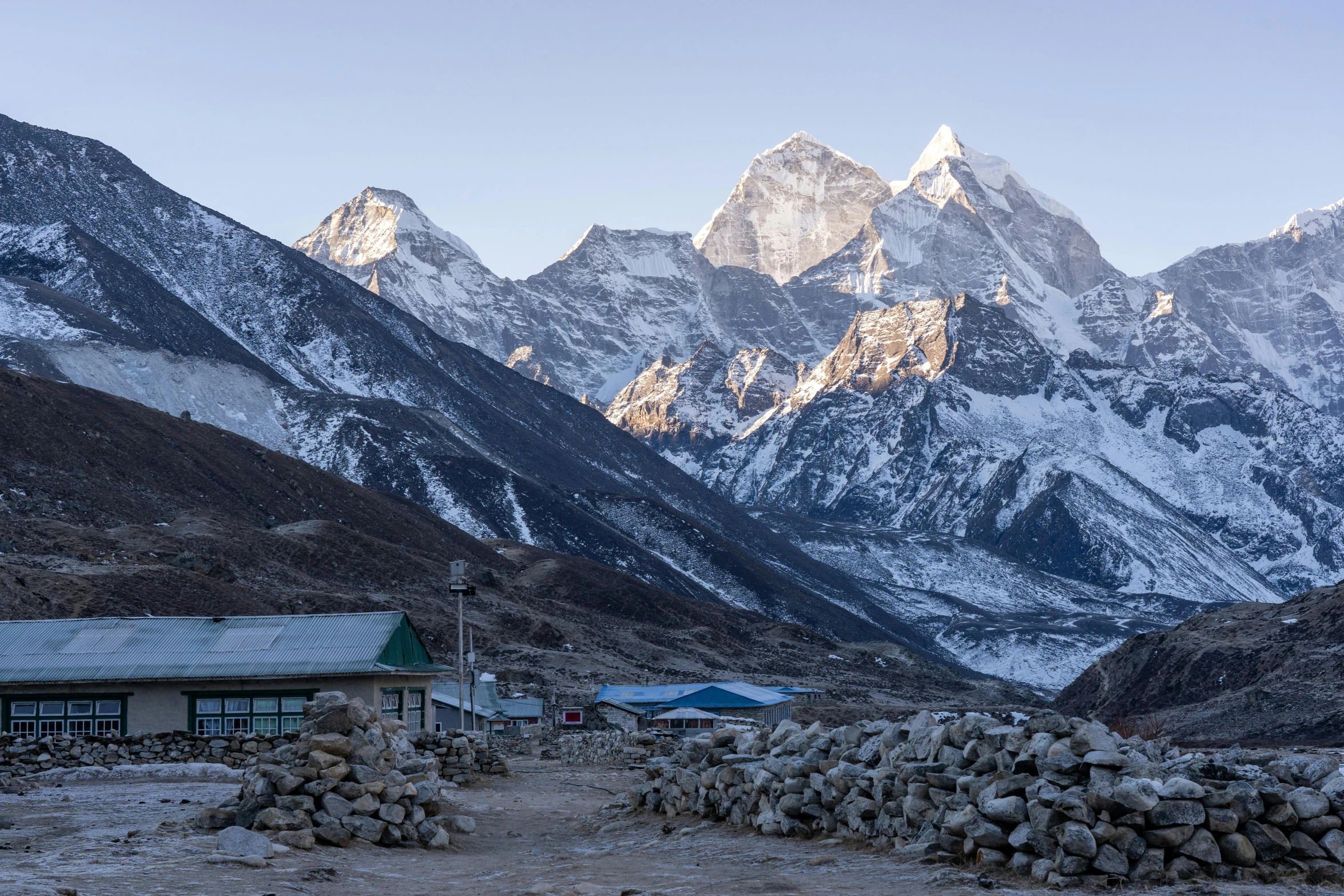 snow covered mountain peaks with a small house