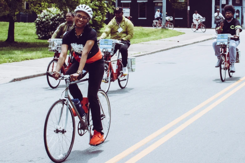 a group of bicyclists riding on a city street