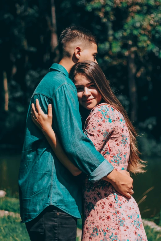 a couple is hugging in a field while standing next to each other