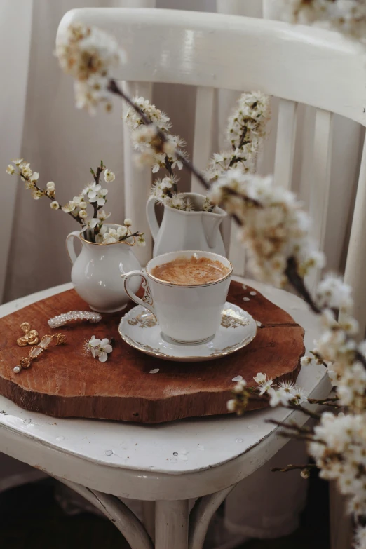 a cup of coffee sits on a plate with some almonds