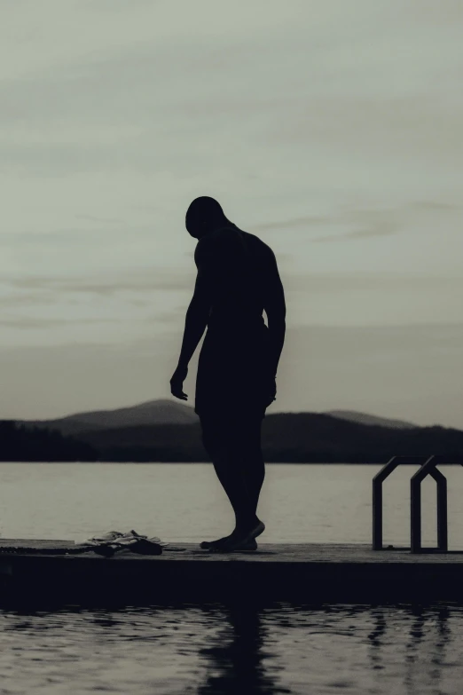 a man standing on a dock with a suitcase next to him