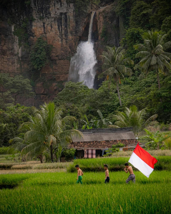 a large waterfall in the background with children playing with it