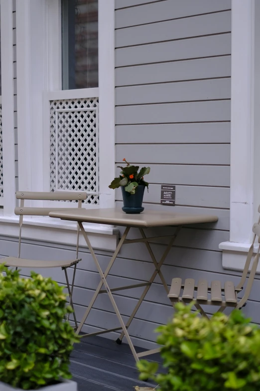 a table and chair are sitting on the front porch