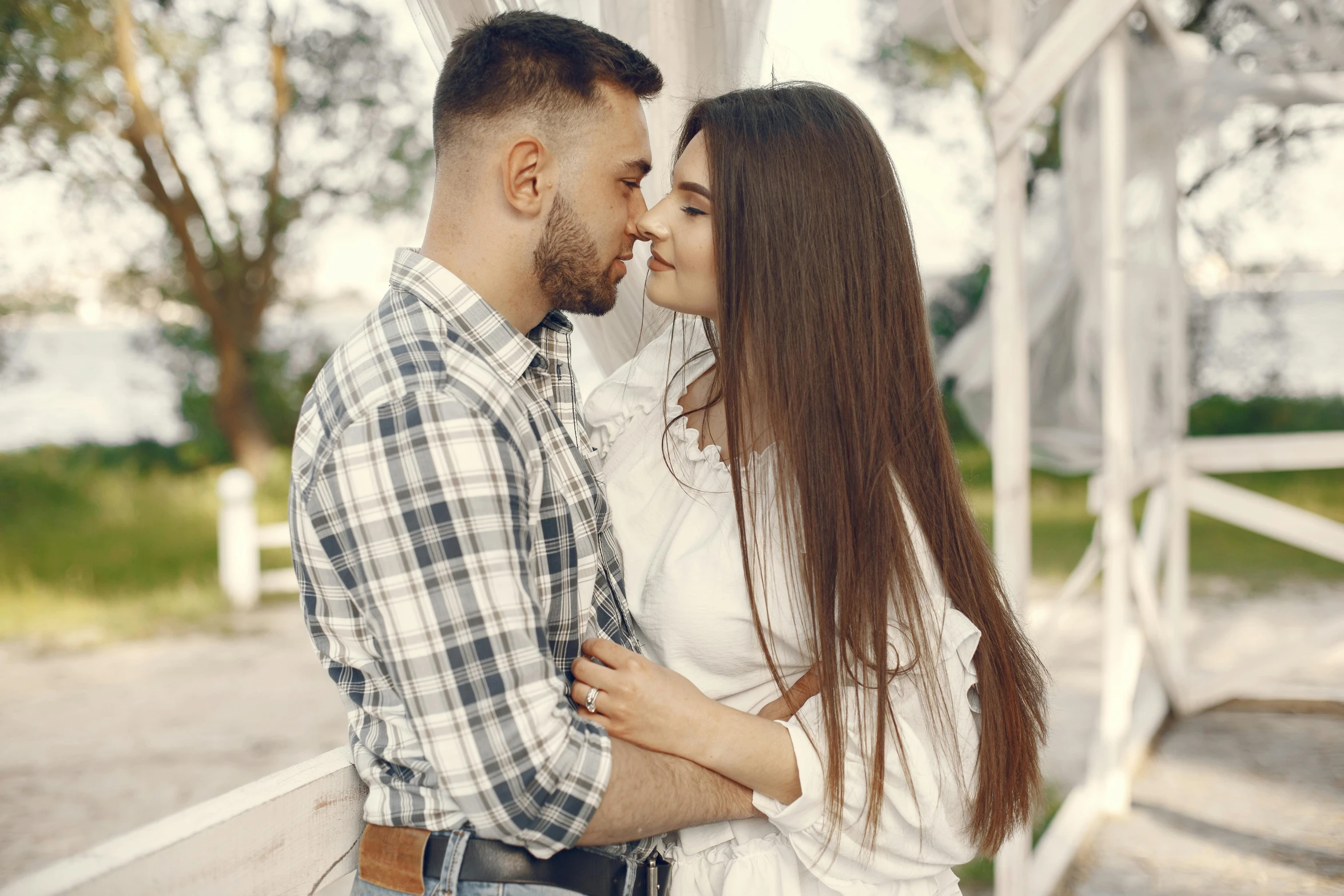 a young couple cuddling under a gazebo