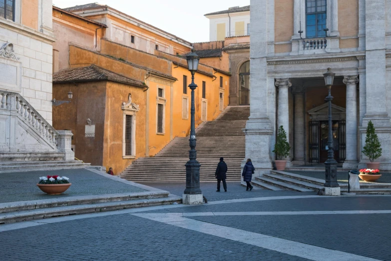 two men are walking up stairs in a courtyard