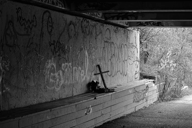 a cross is placed between two benches, in a tunnel