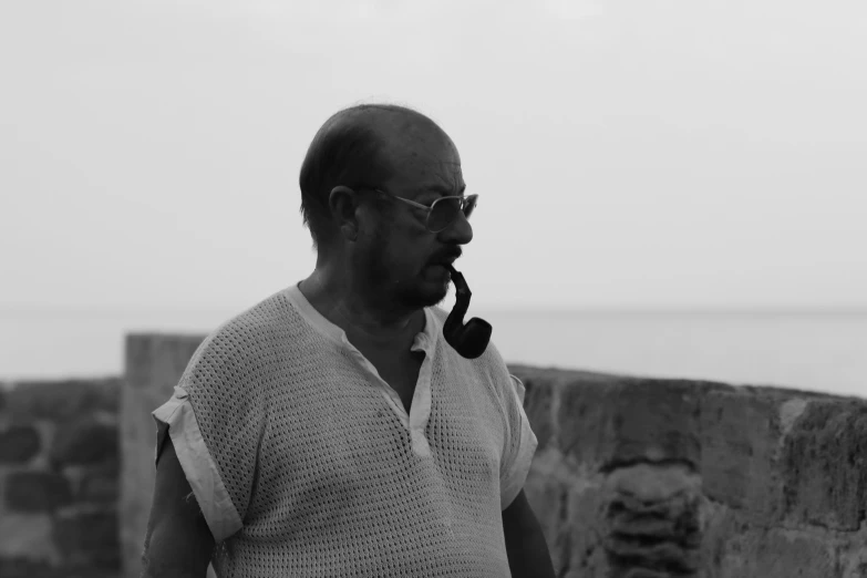 an older man smoking soing on a telephone