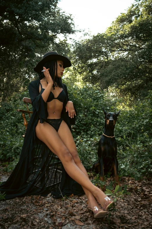 woman dressed in black sitting on the ground next to her dog