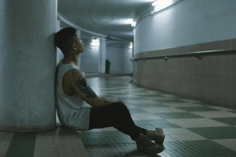 a boy is sitting in an underground corridor