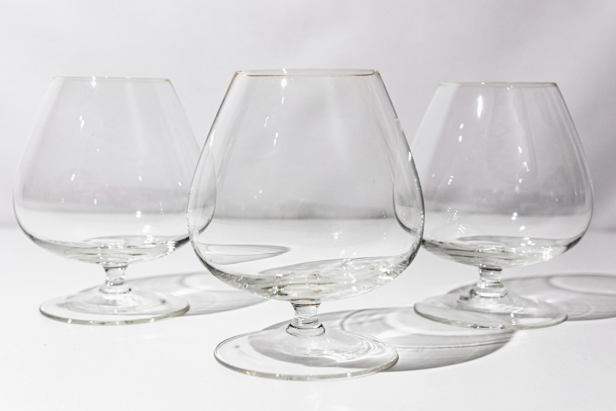 a group of four wine glasses on a table