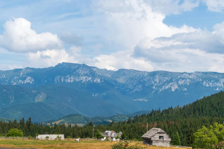 a mountain range is in the background with several barn buildings