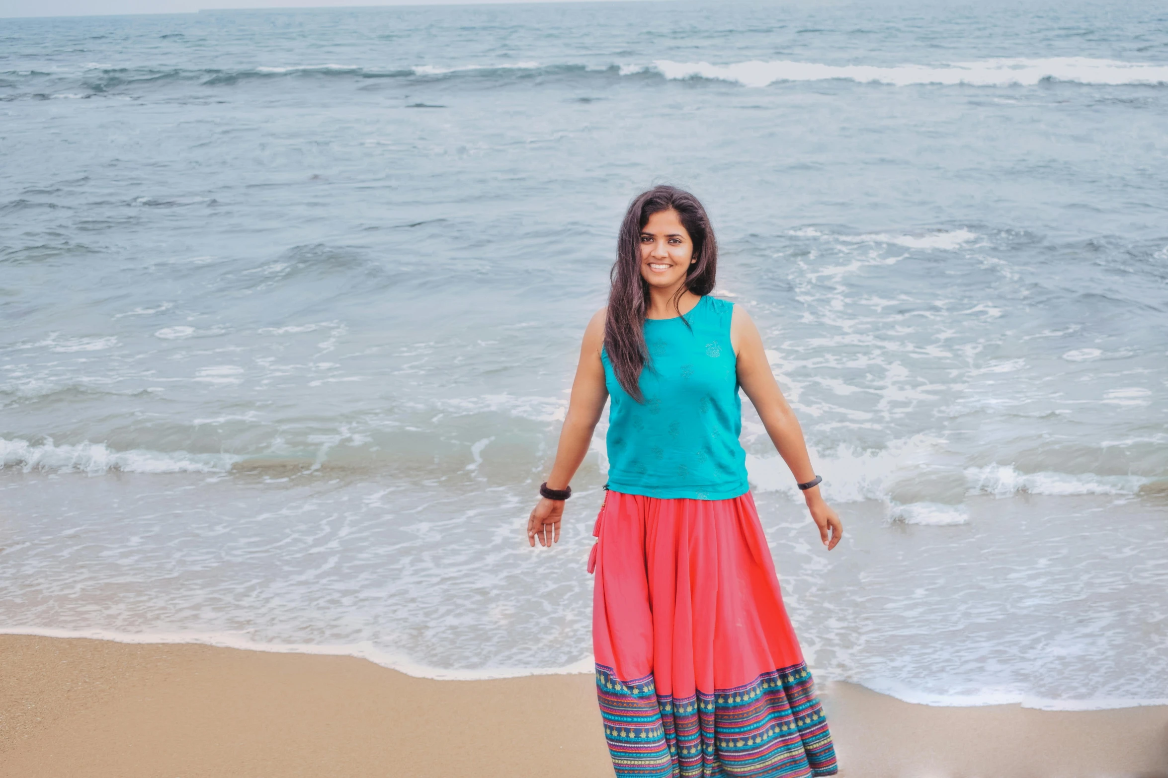 a woman in a long skirt on the beach