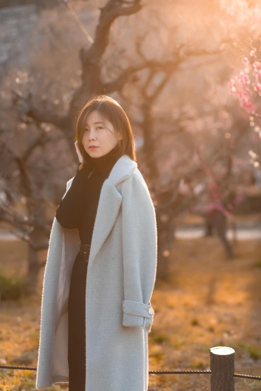 a beautiful woman is standing outside in the sun