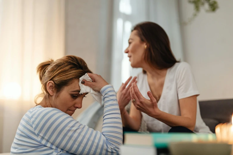 a woman is crying and a woman wipes her hands