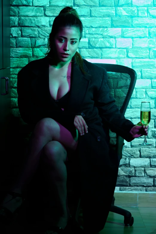 a woman dressed in dark clothing and with a glass of wine