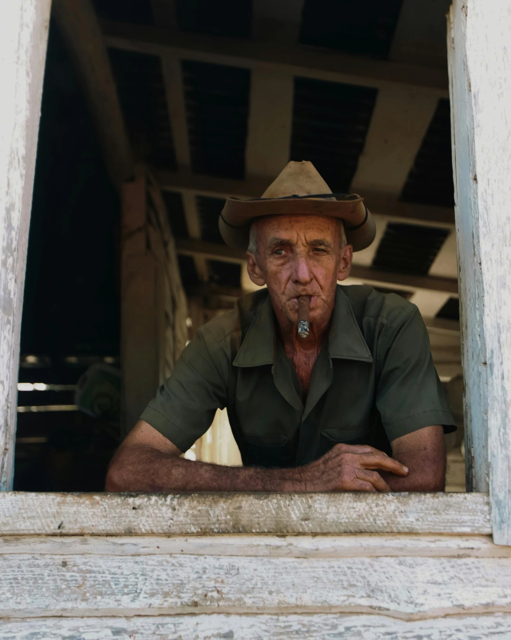 a man with a hat stares out the window