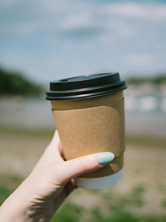 a cup is held up and being held by someone